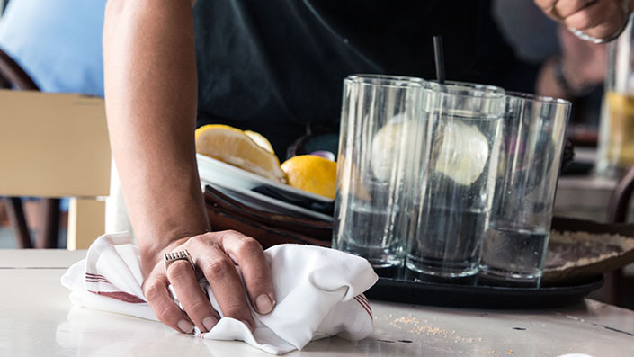 cleaning a table with a cloth