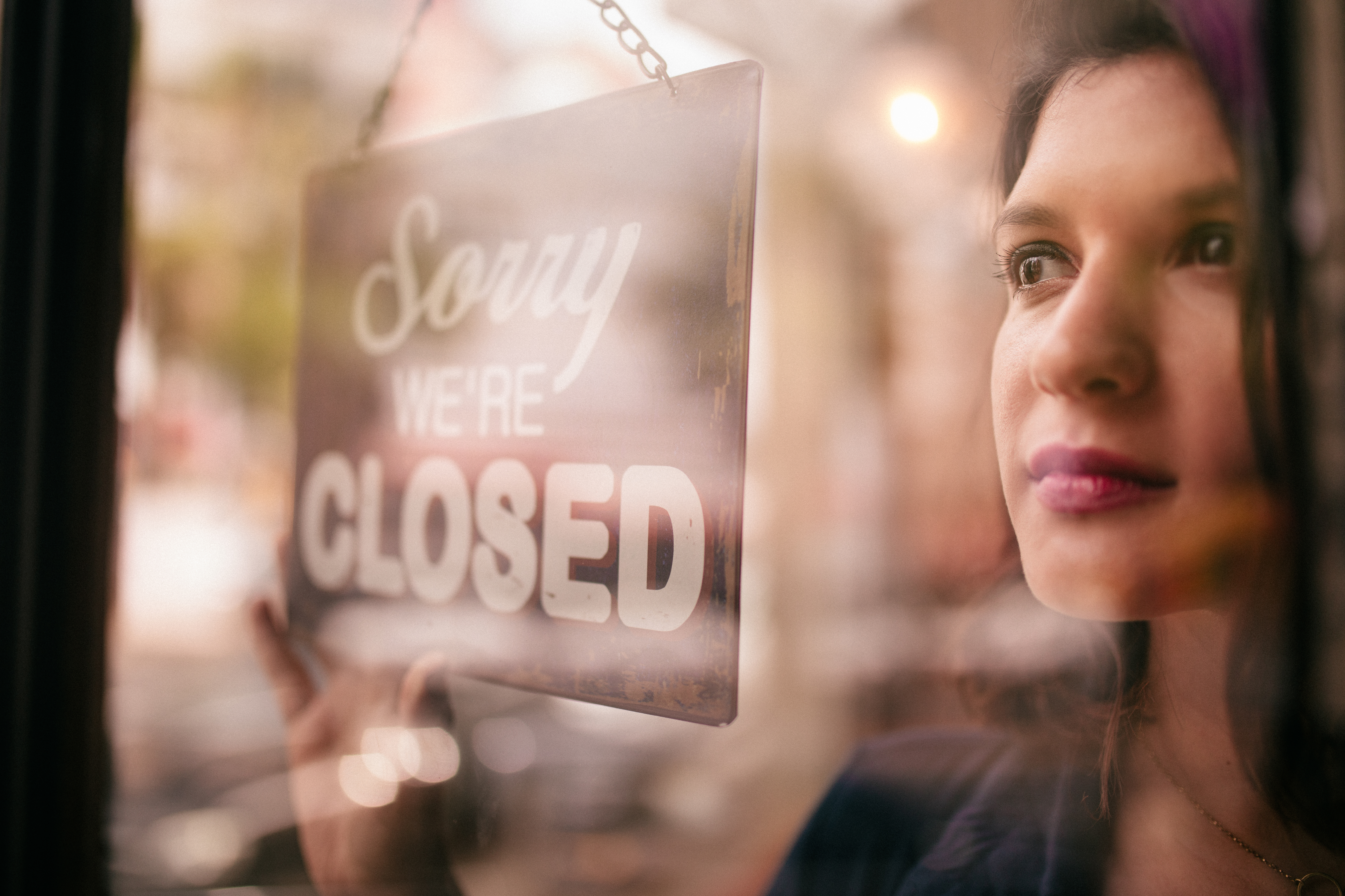 woman standing next to a closed sign