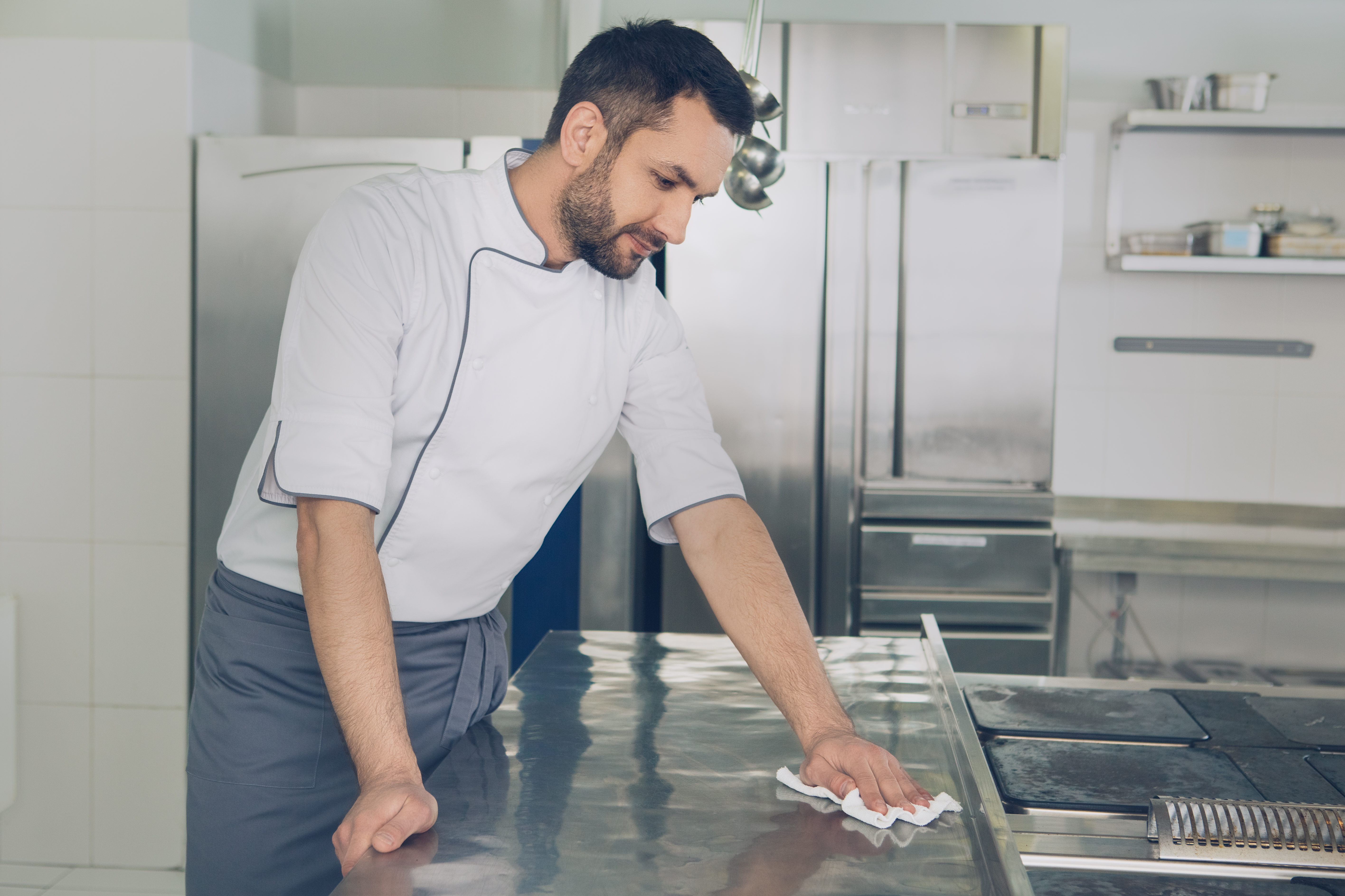 man wiping down a surface in a restaurant