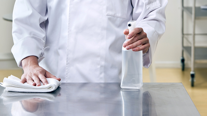 kitchen worker cleaning surface